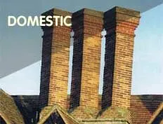 Domestic: three tall brick chimney stacks against a blue sky