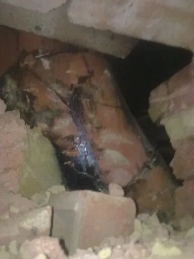 Chimney breast opened up to reveal a flue blocked with tar