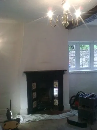 Fireplace in a living room during works, with dust sheets down