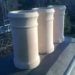 Three new buff chimney pots in place on a restored stack