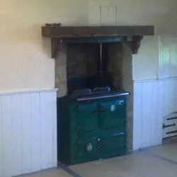Range cooker set into a restored fireplace under a timber beam