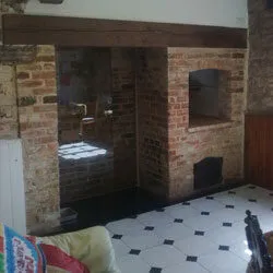 Completed inglenook fireplace with new brickwork and a timber beam