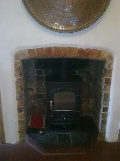 Small stove in an arched brick fireplace