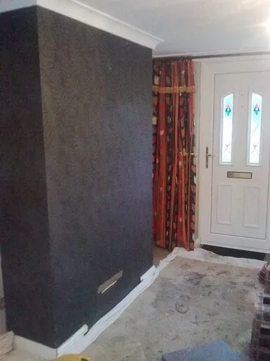 Chimney breast clad in dark tiles beside a front door